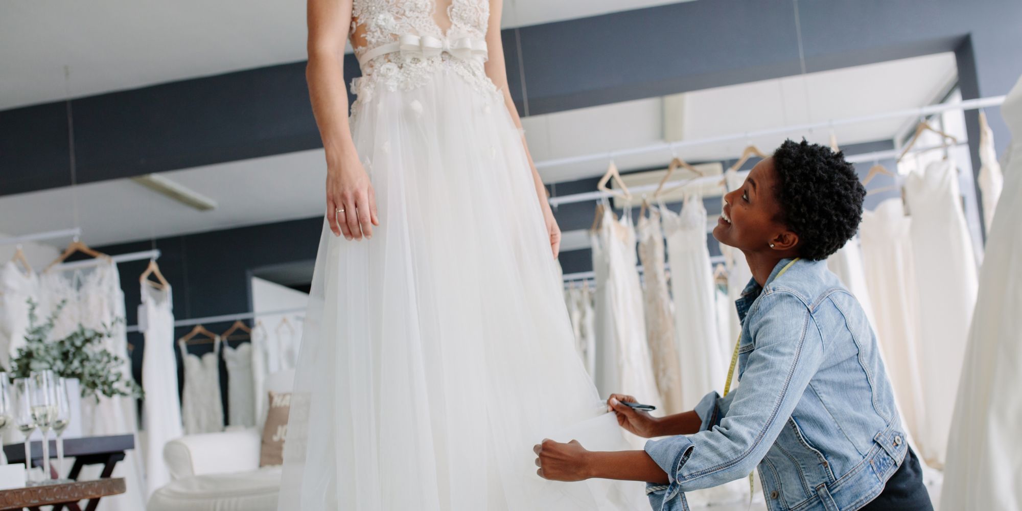 bridal stylist helping bride to be with bridal dress fitting