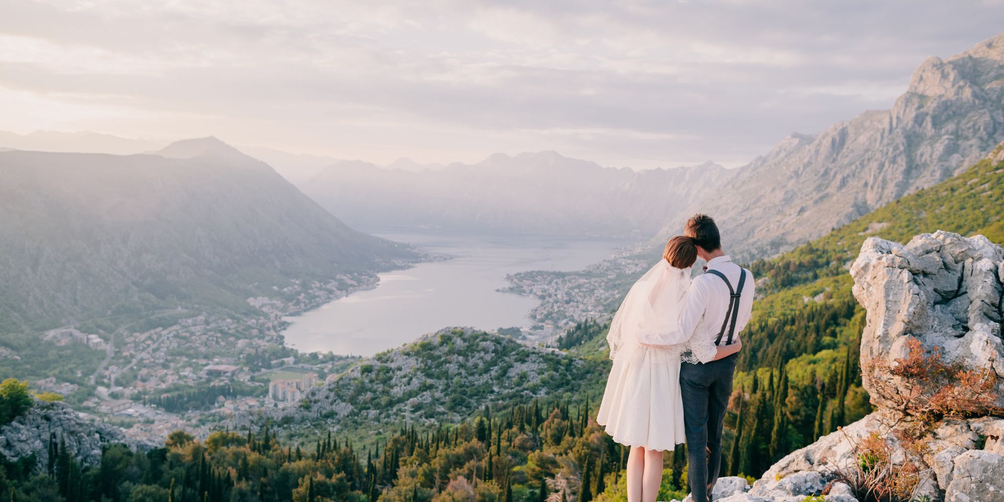 Bride and groom looking over large valley